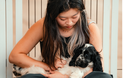 Student cuddling a puppy